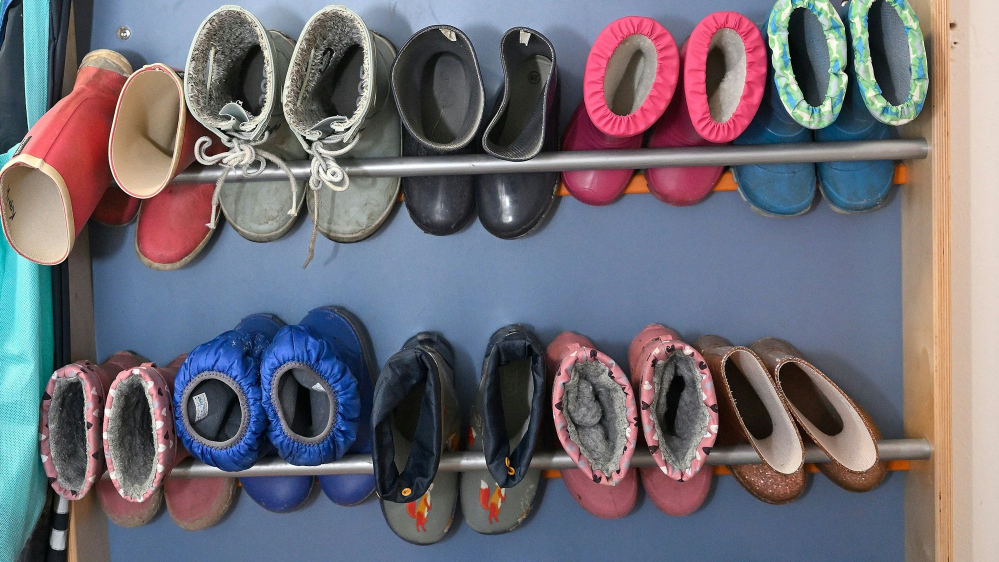 Kinder Gummistiefel stehen in einem Regal.