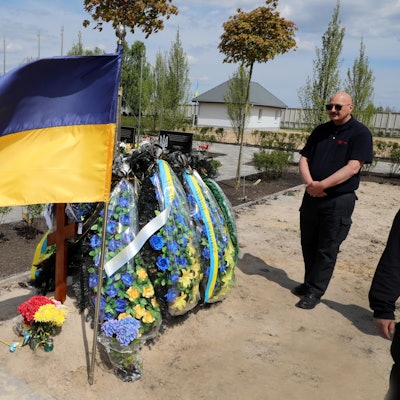 Über einem frisch aufgeschütteten Grab weht eine ukrainische Fahne.