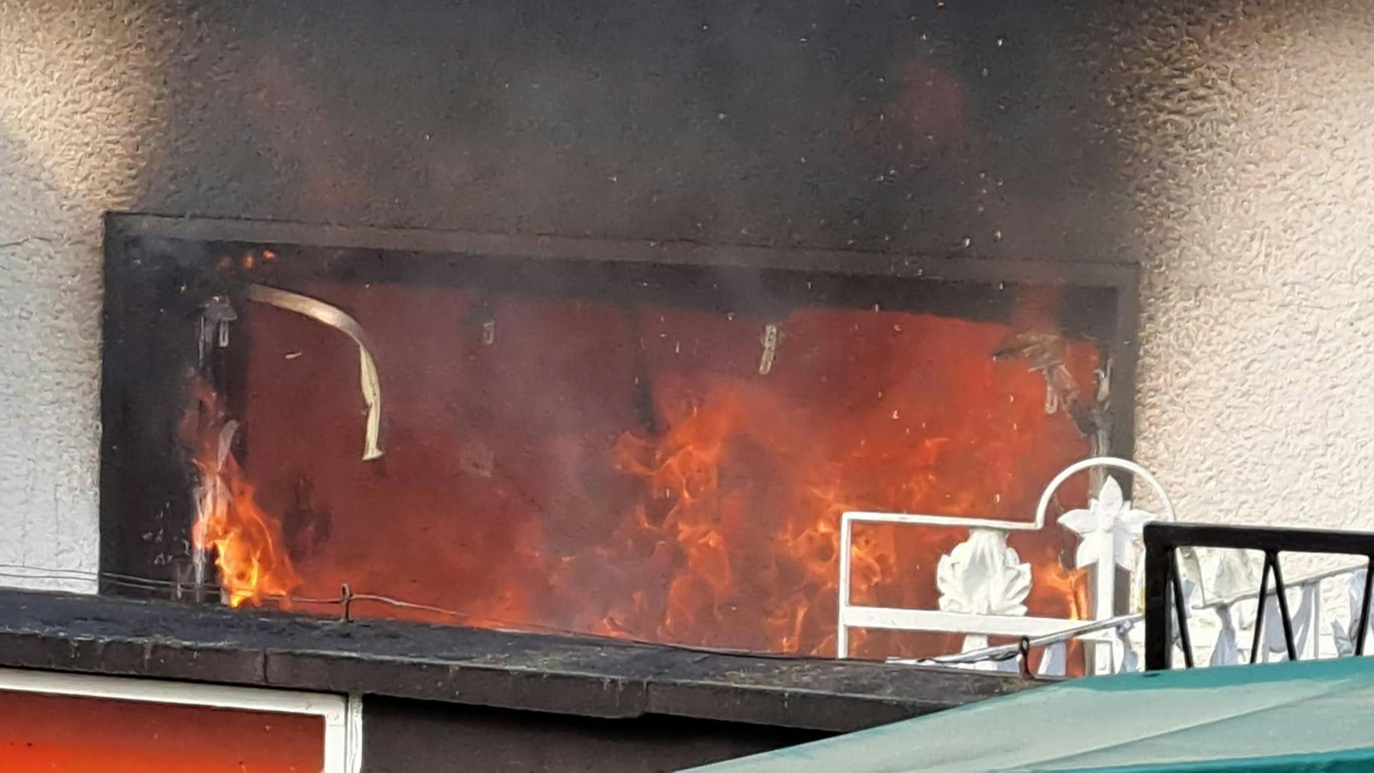 Durch das Fenster sind die Flammen zu sehen.