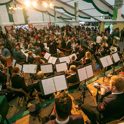 In einem voll besetzten Festzelt spielt ein Musikzug.