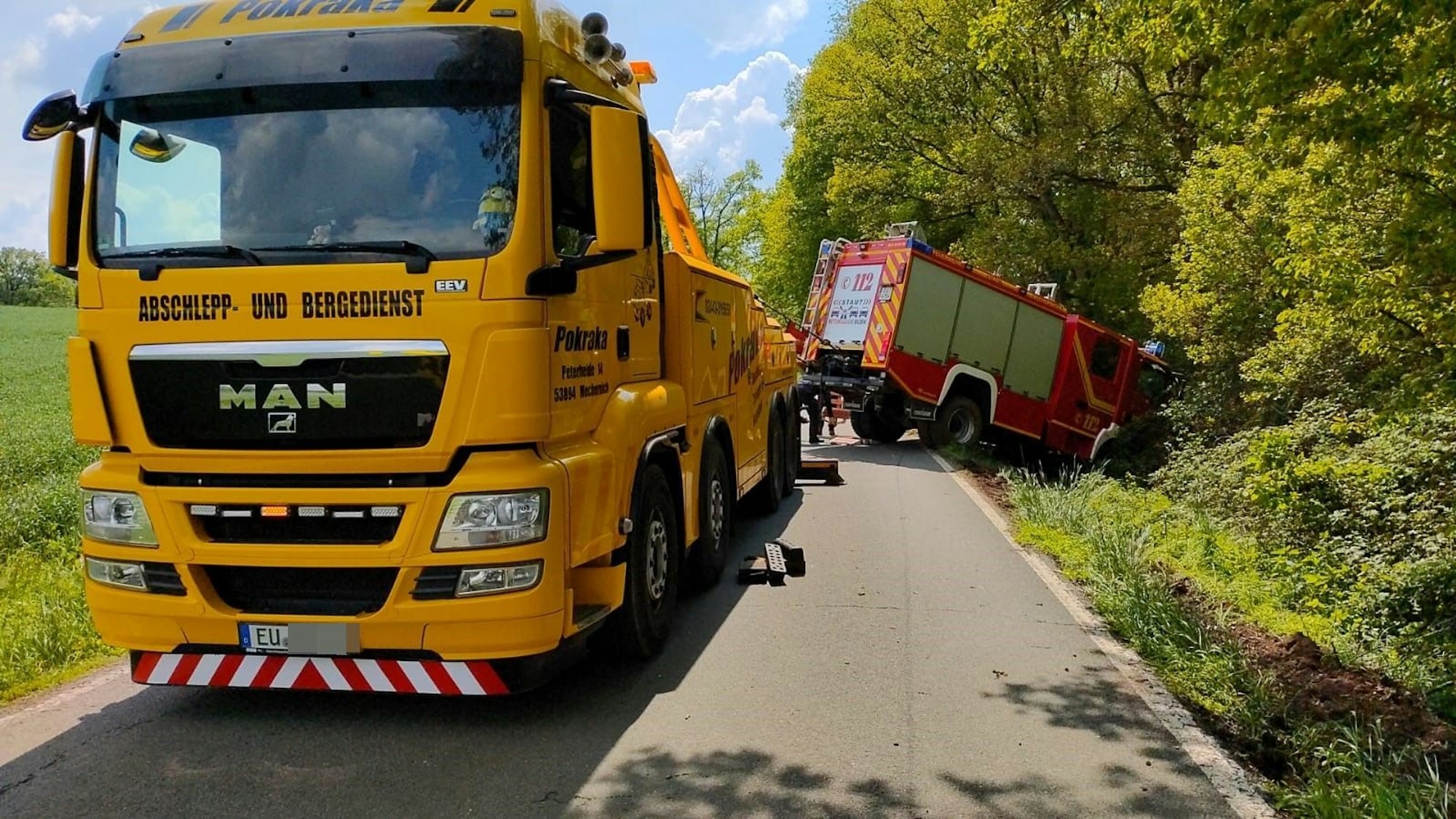 Ein Abschlepp-Lkw zieht das Feuerwehrauto aus dem Graben.