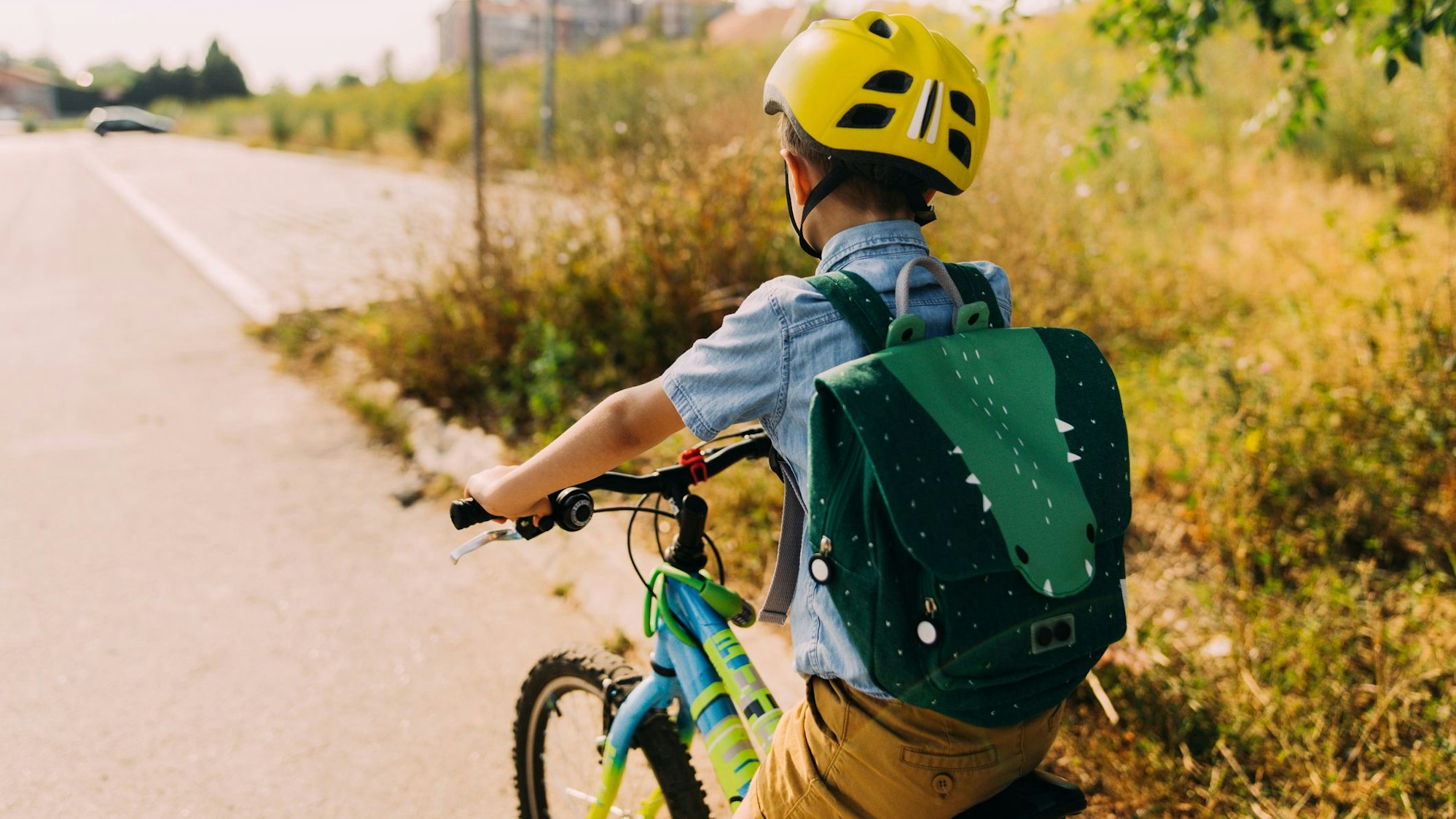 Ein Junge fährt mit dem Rad zur Schule.