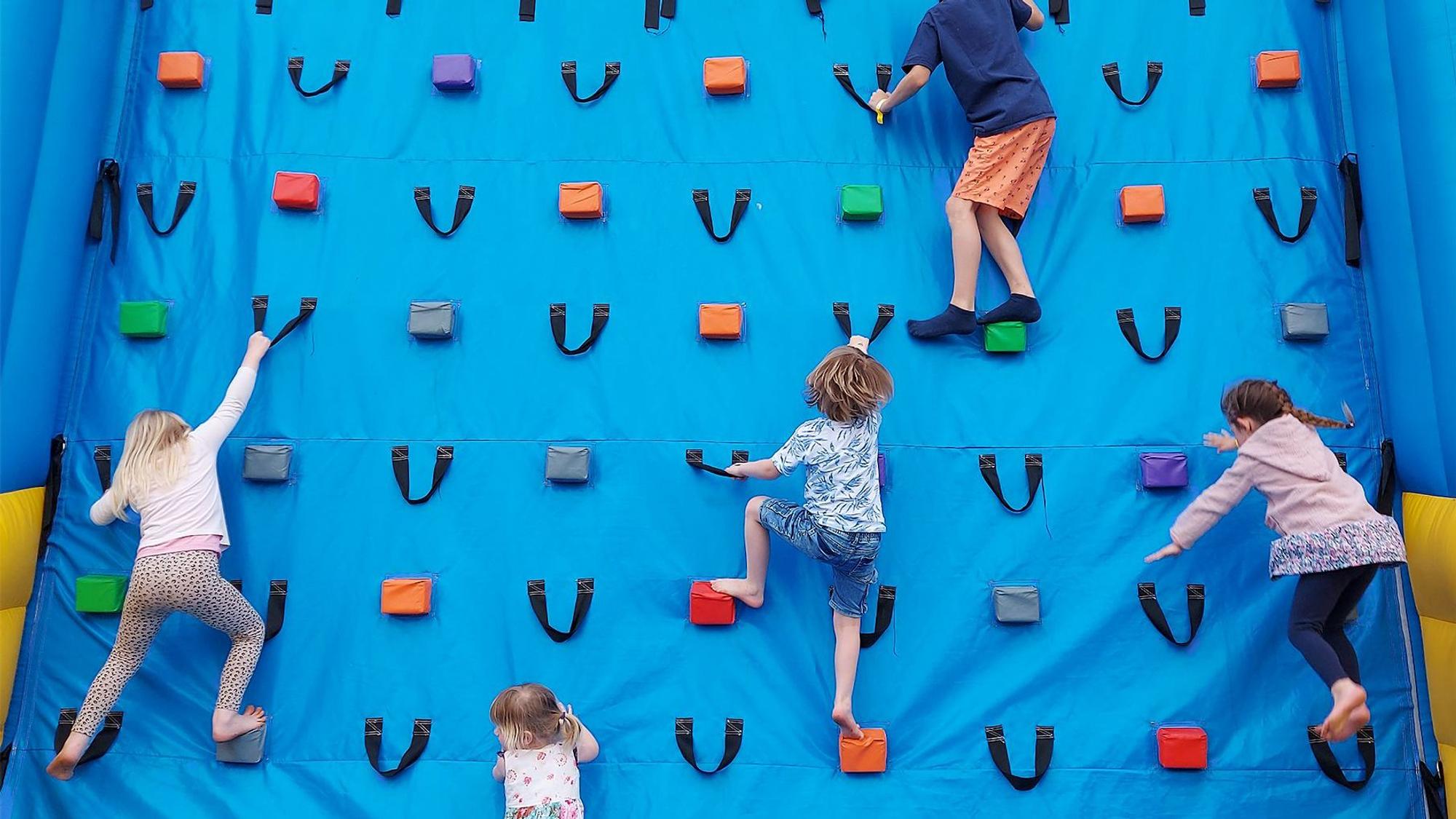 Kinder an einer Kletterwand bei „Jump im Park“.