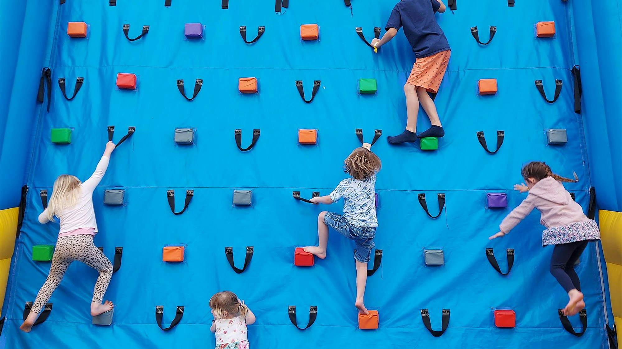 Kinder an einer Kletterwand bei „Jump im Park“.