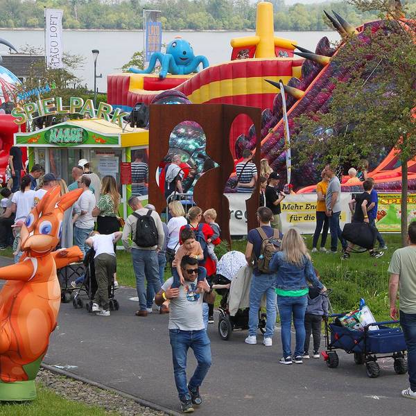 „Jump im Park“ in Zülpich ist ein Hüpfburgenfestival. Vor einer Vielzahl an verschiedenen Hüpfburgen sind junge wie erwachsene Besucher und Besucherinnen zu sehen.