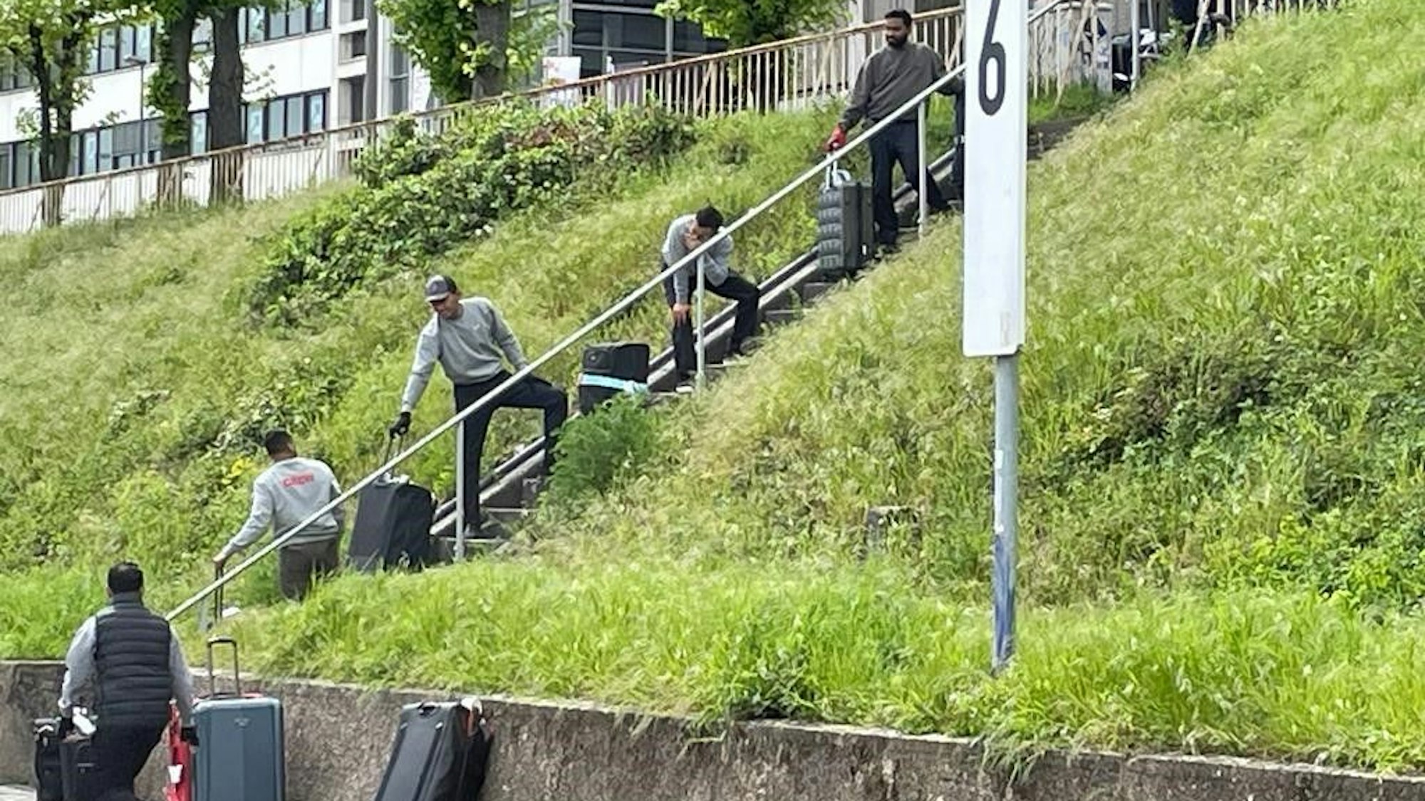 8.5.2023 Zustände wegen Sperrungen am Rhein: Die Koffer der Schifffahrtsgäste an der Trankgassenwerft werden durch eine Kette von Mitarbeitern von der Rheinuferstraße auf Anliegerebene gehoben.