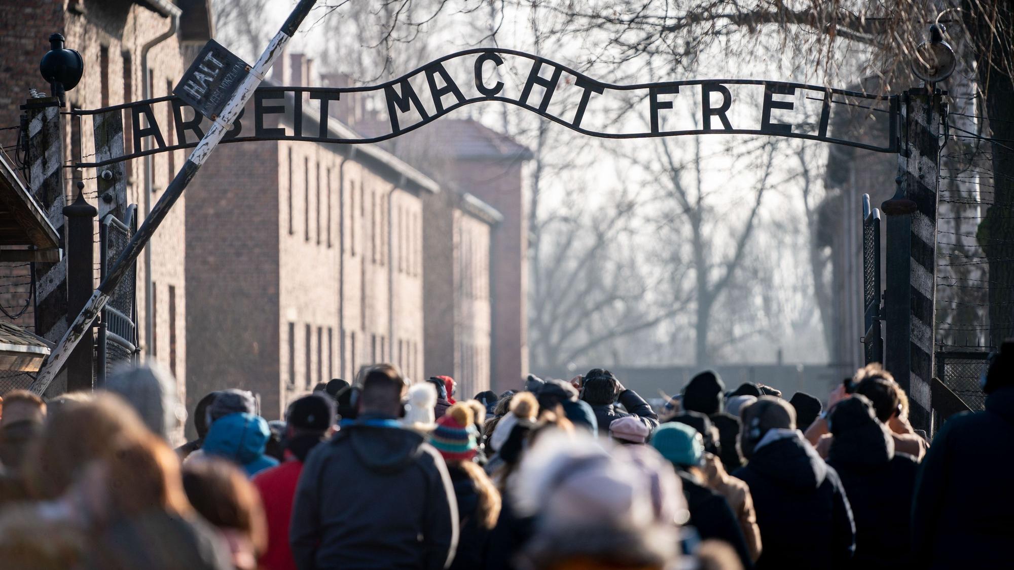 Besucher gehen durch den Eingang des früheren Konzentrationslagers Auschwitz. Zwei Schüler aus Sachsen sollen den sogenannten Hitler-Gruß in Auschwitz gezeigt haben. (Symbolbild)