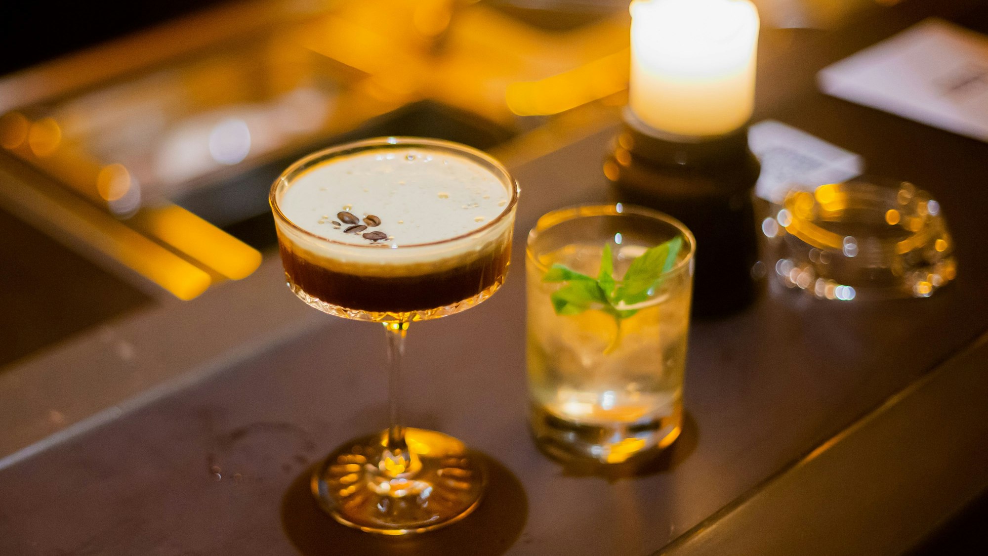 Ein Espresso-Martini und ein Mindy-Cocktail stehen auf dem Tresen.