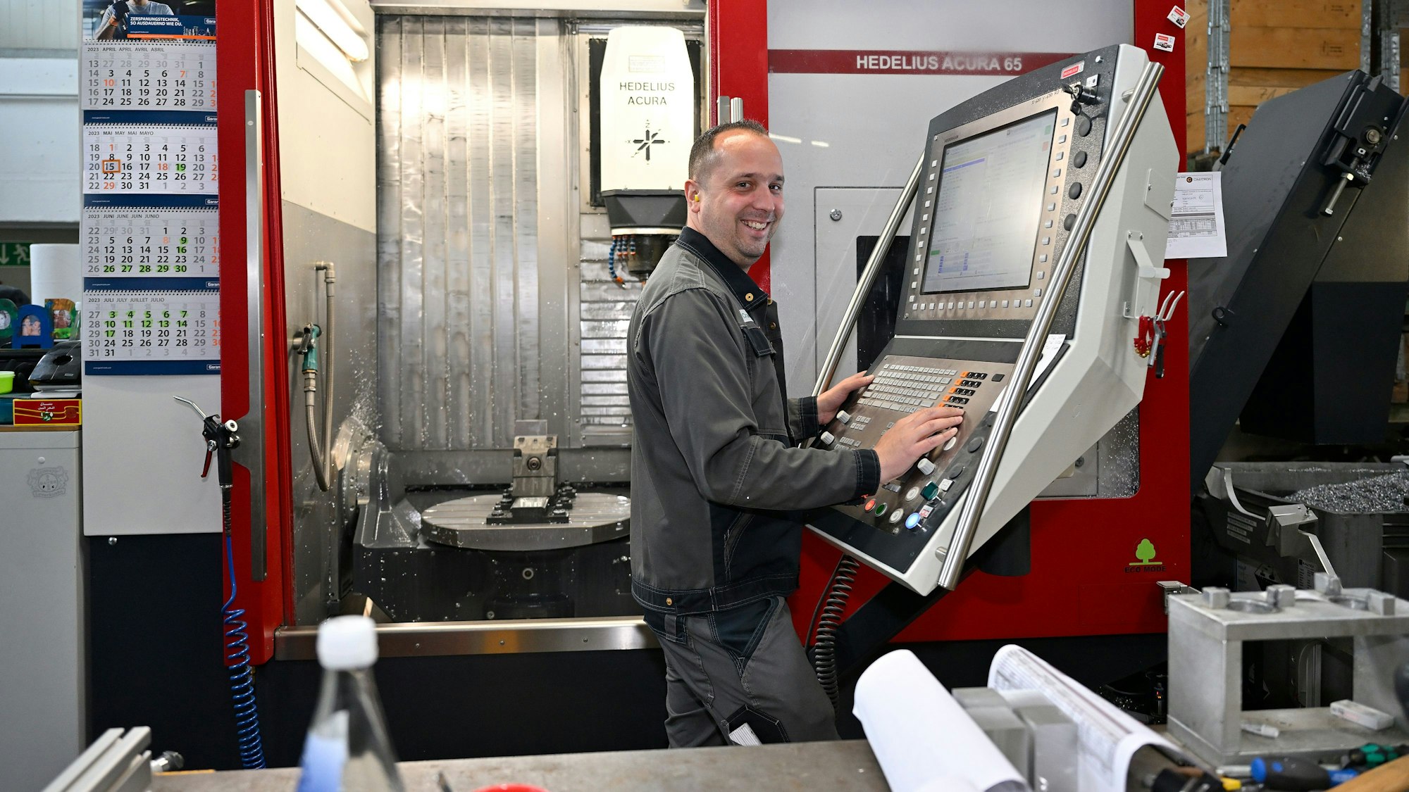 Ein Mann steht vor einem Industriecomputer.