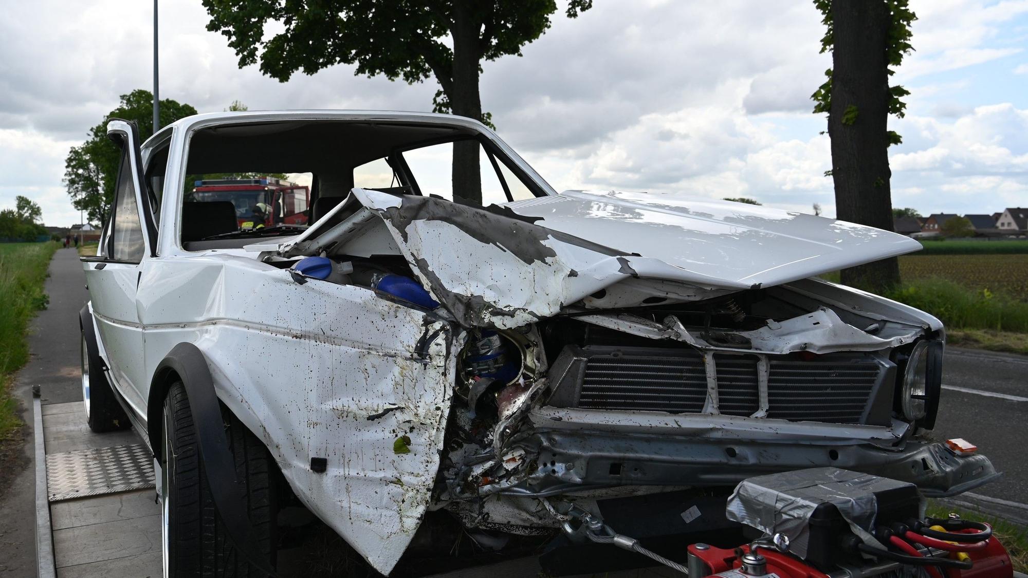 Das Bild zeigt einen im Frontbereich beschädigten weißen VW-Golf I.