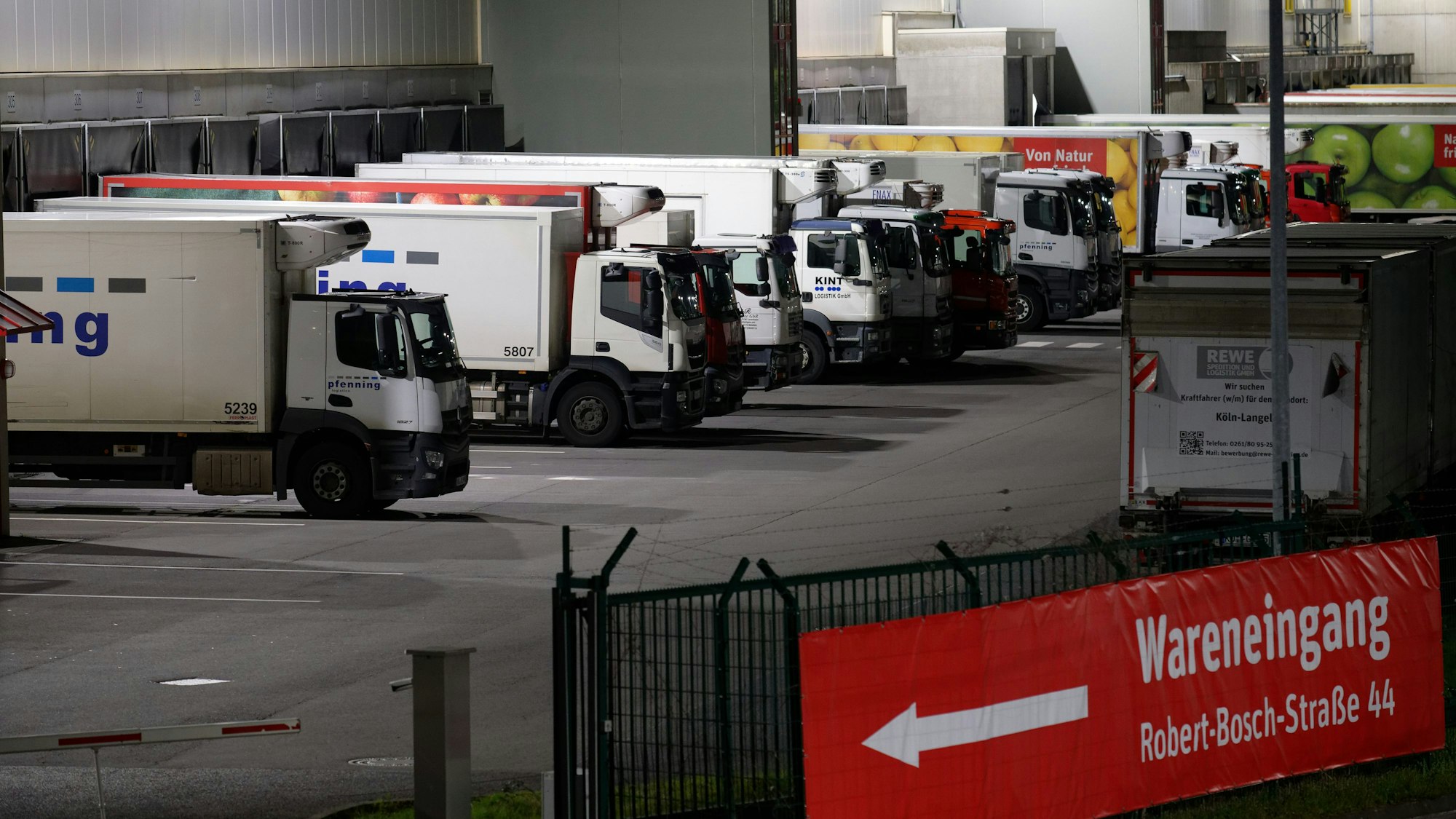 Lastwagen stehen in den Morgenstunden auf dem Gelände der REWE Zentrale in Köln-Langel.