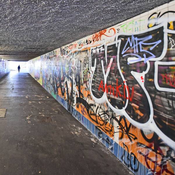 Graffitis füllen die Wände eines Fußgängertunnels.