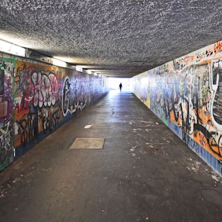 Graffitis füllen die Wände eines Fußgängertunnels.