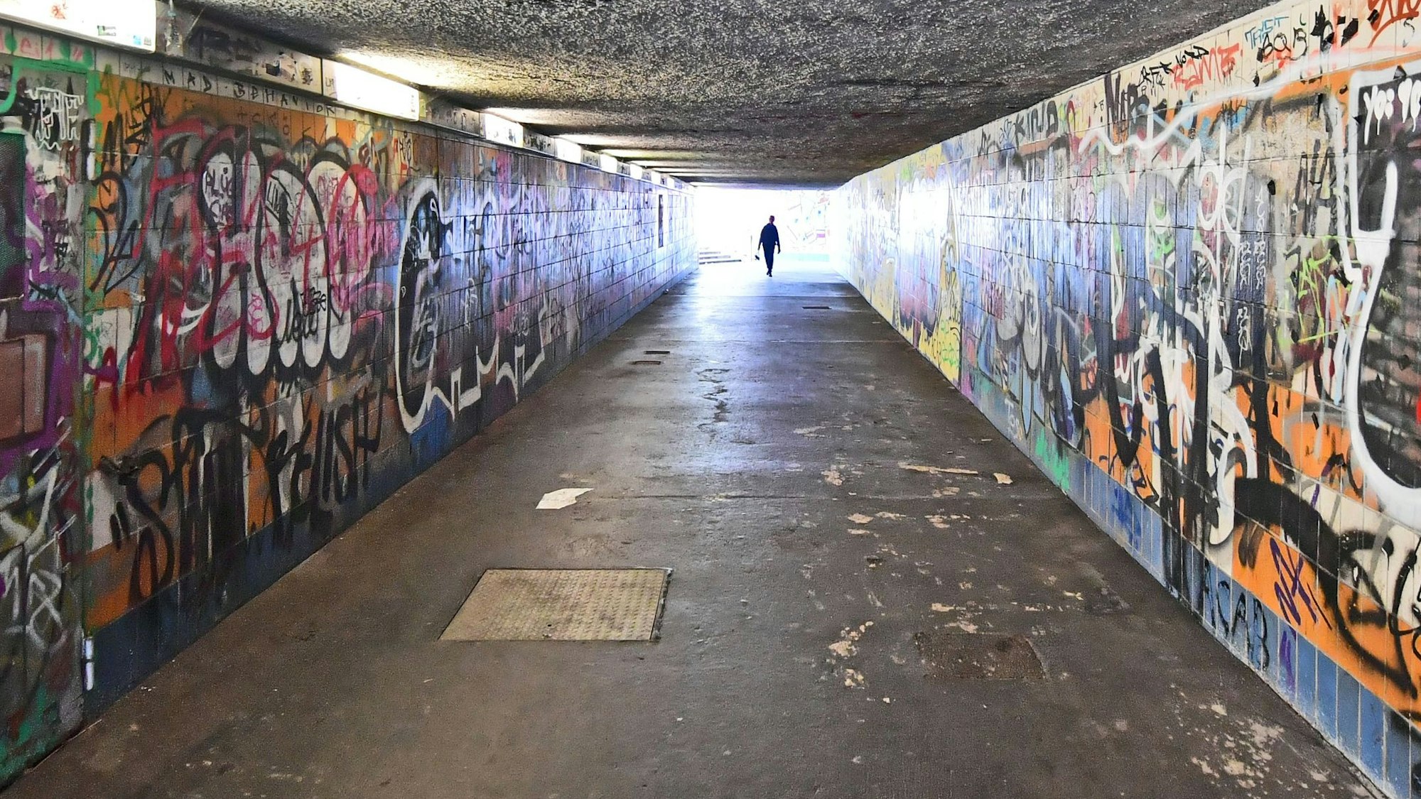 Graffitis füllen die Wände eines Fußgängertunnels.