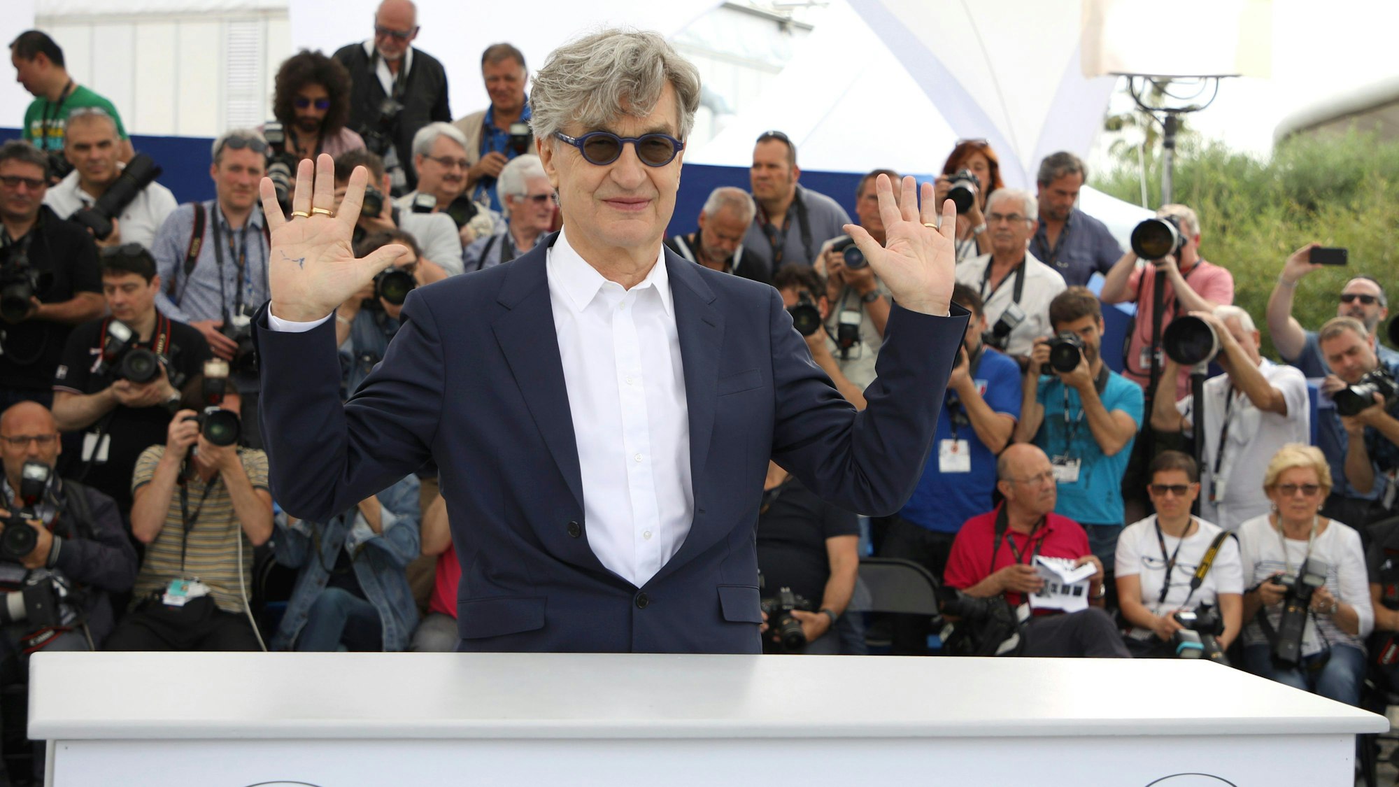 Wim Wenders kommt zum Fototermin im Rahmen des 71. Filmfestivals in Cannes. Er winkt der Menge zu.