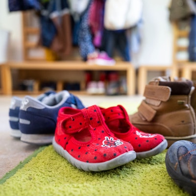 Kinderschuhe stehen in einer Garderobe einer Kita. (Symbolbild)dpa