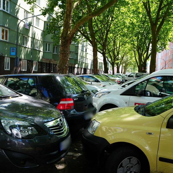Autos stehen dicht gedrängt auf dem Mittelstreifen einer Straße.