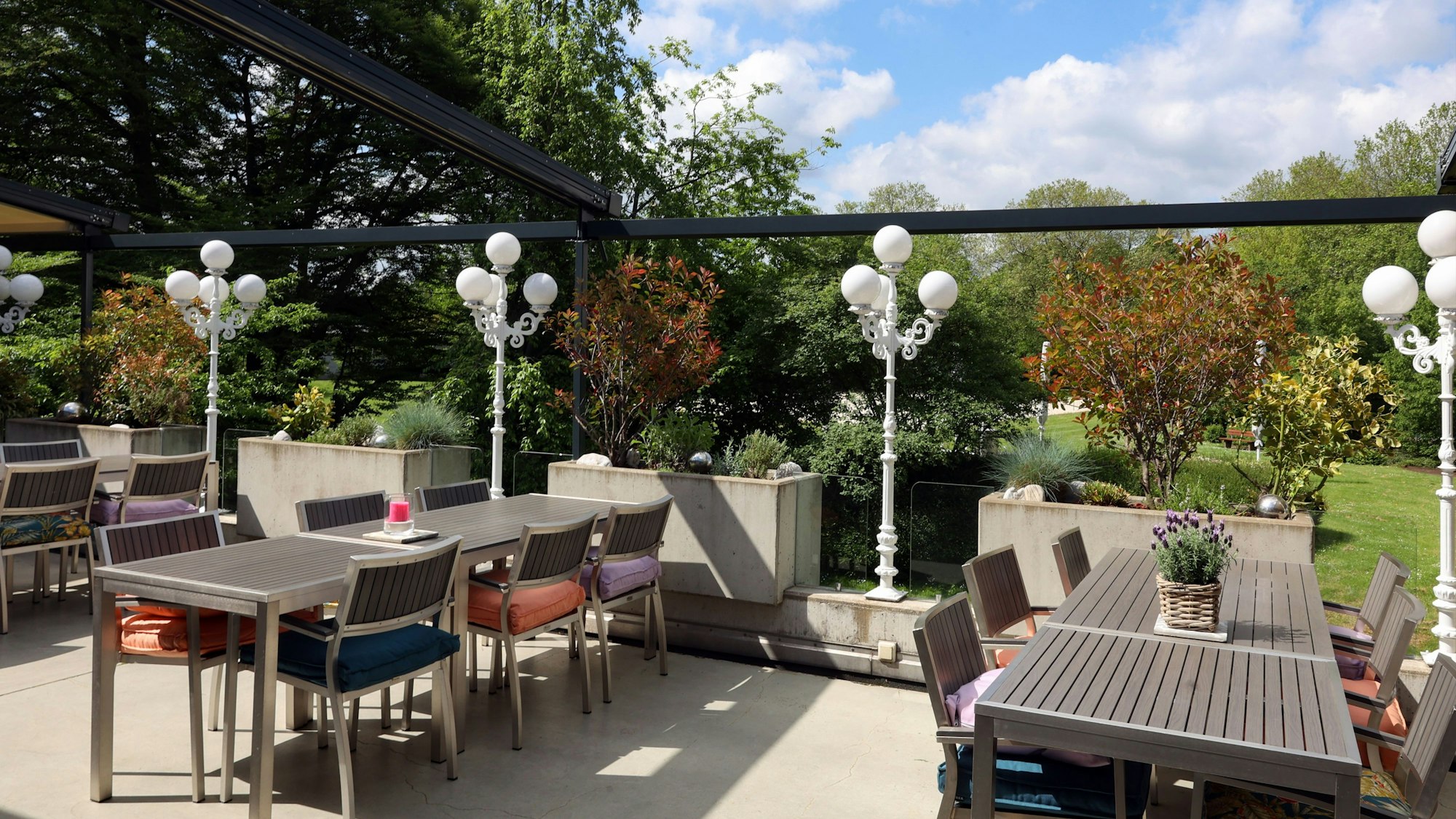 Terrasse mit Tischen, Stühlen und Laternen