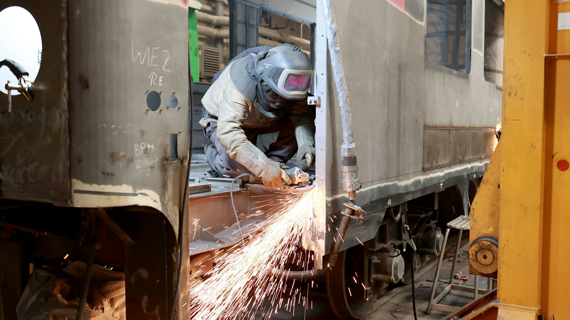 Schweißer der Verkehrs Industrie Systeme GmbH (VIS) arbeiten an einem Eisenbahnwaggon der Schweizer Bundesbahn (SBB).