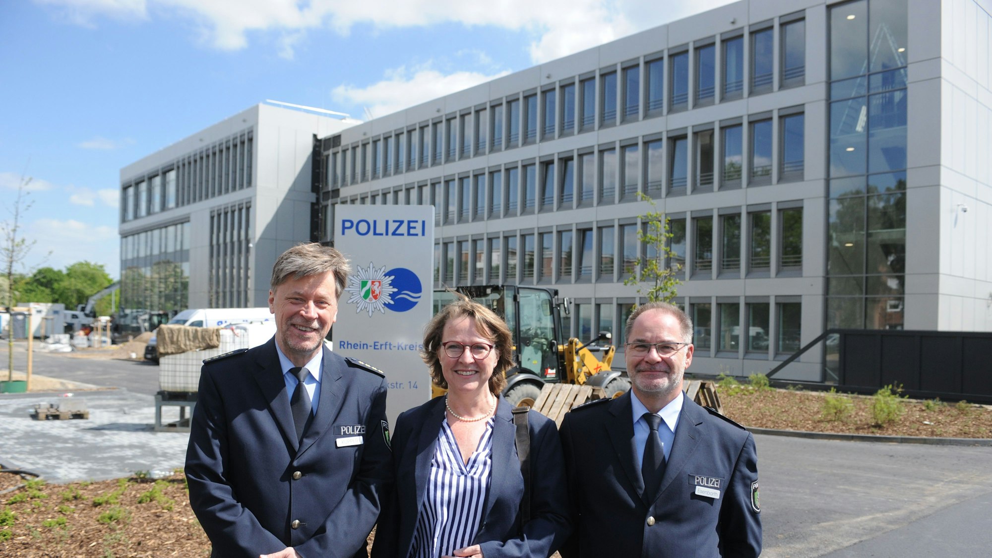 Das Foto zeigt den Leitender Polizeidirektor Roland Küpper, Ulrike Heimbüchsel und Paul Eisenbarth vor dem fast fertigen Polizeigebäude in Bergheim.