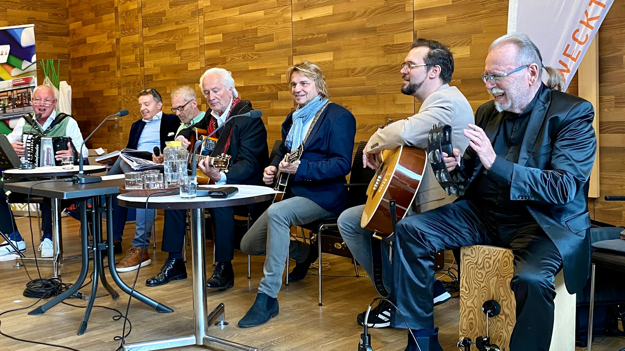 Es sind die Bandmitglieder beim Musik spielen zu sehen.