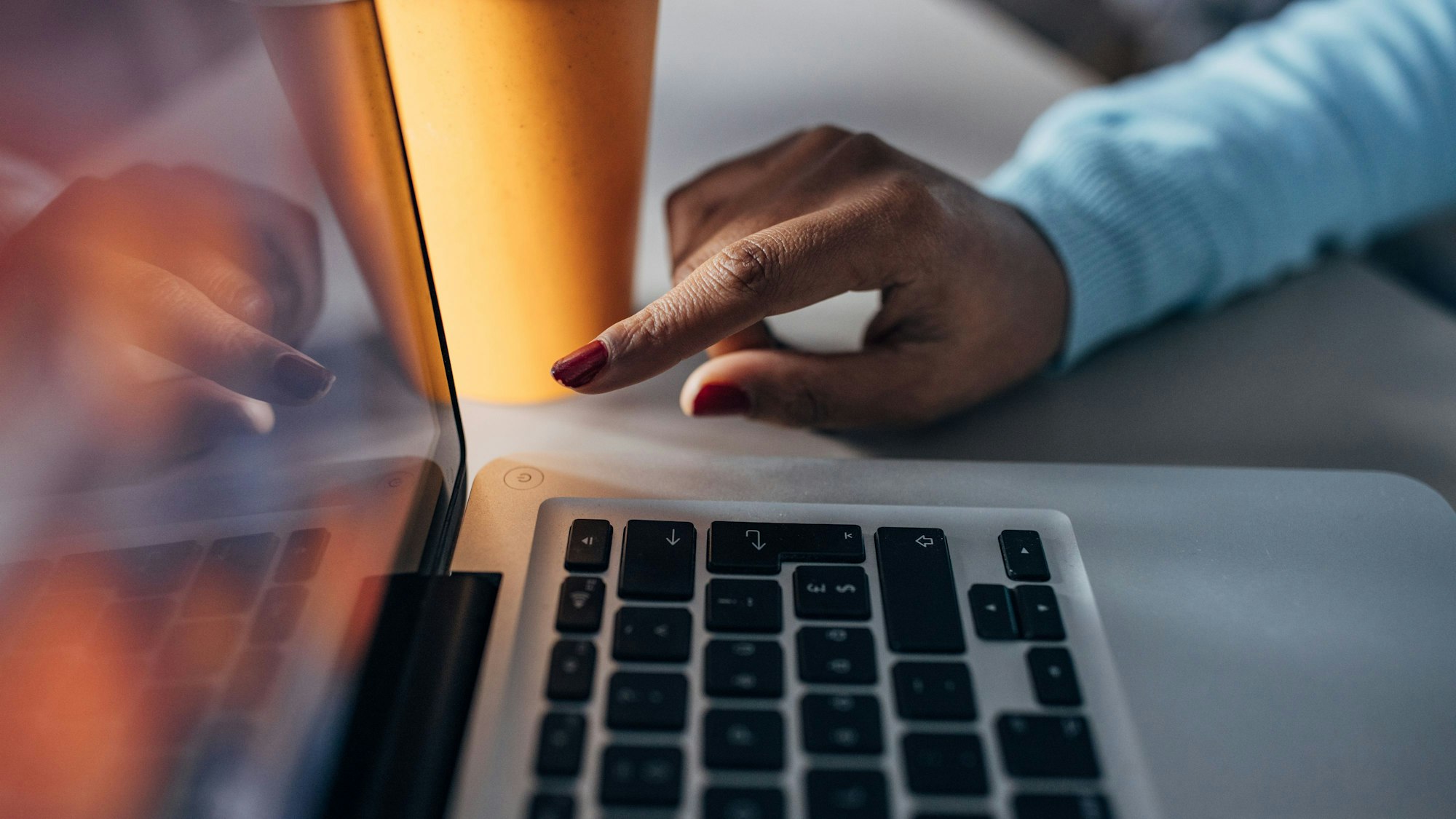 Eine Frau drückt auf den Aus-Schalter am Laptop