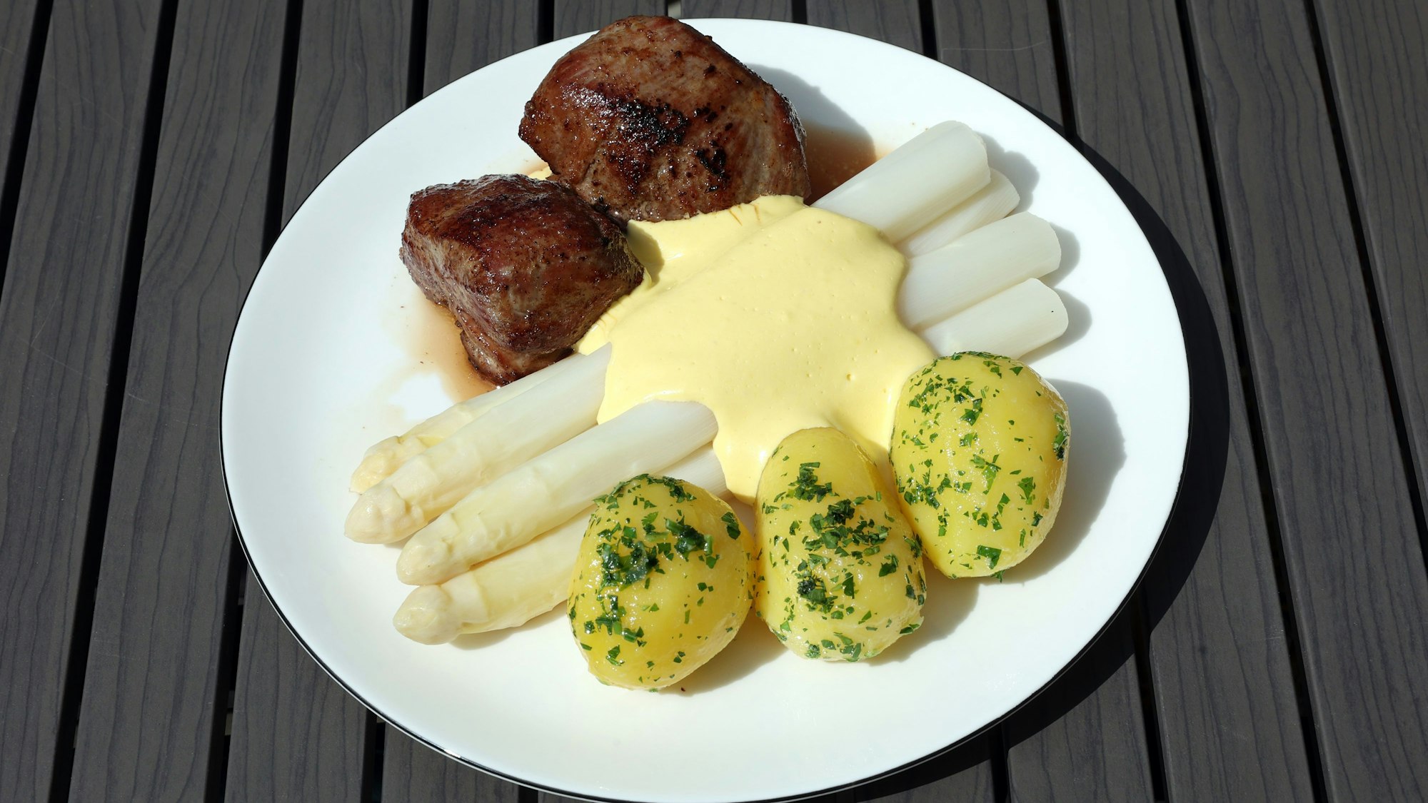 Fleisch, Kartoffeln und Spargel auf einem Teller