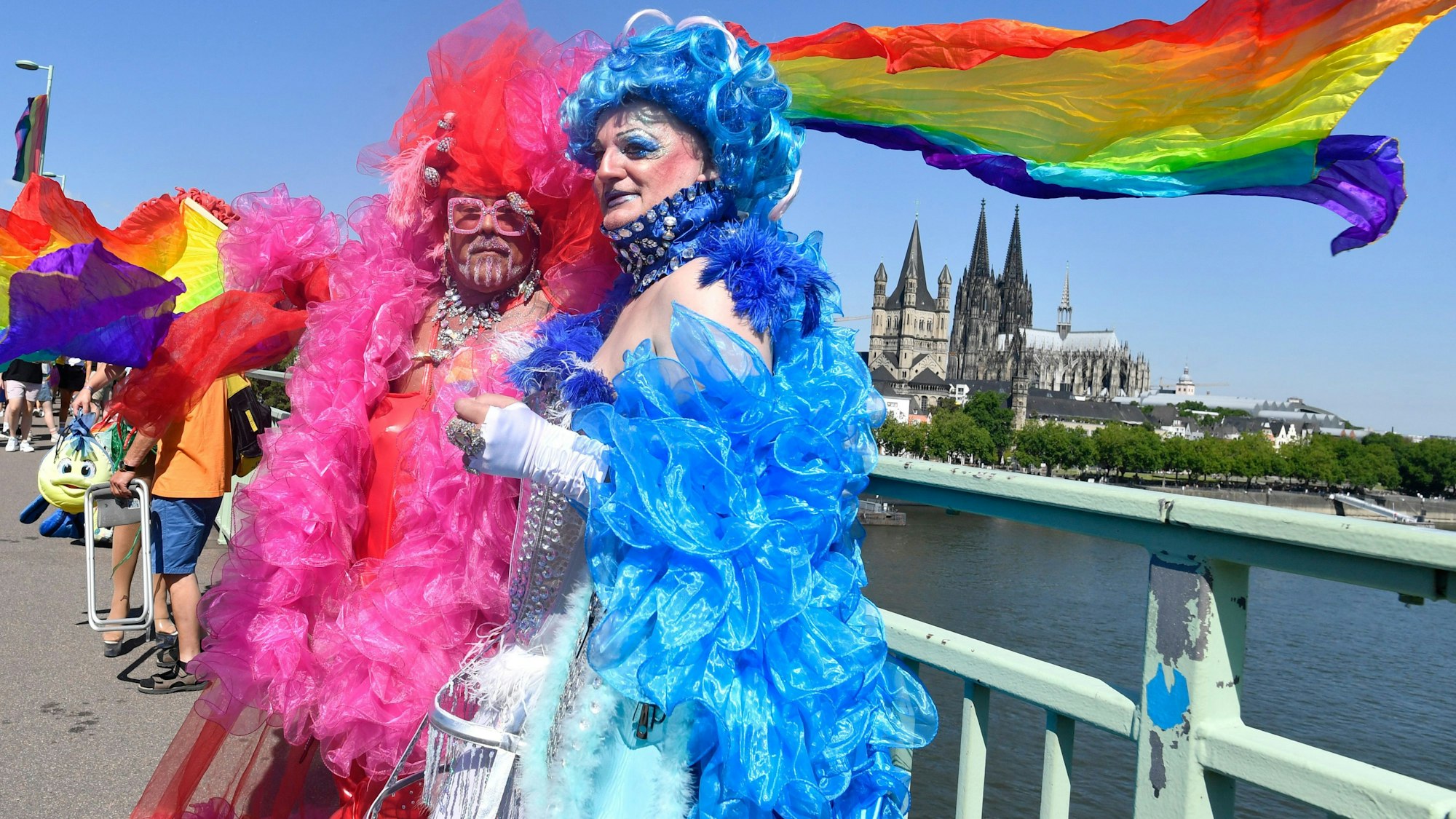 03.07.2022, Nordrhein-Westfalen, Köln: Horst und Uwe feiern bei der diesjährigen CSD-Parade am Start auf der Deutzer Brücke. Im Hintergrund ist der Kölner Dom zu sehen. Manche Menschen hatten sich für die CSD-Parade fantasievoll verkleidet.