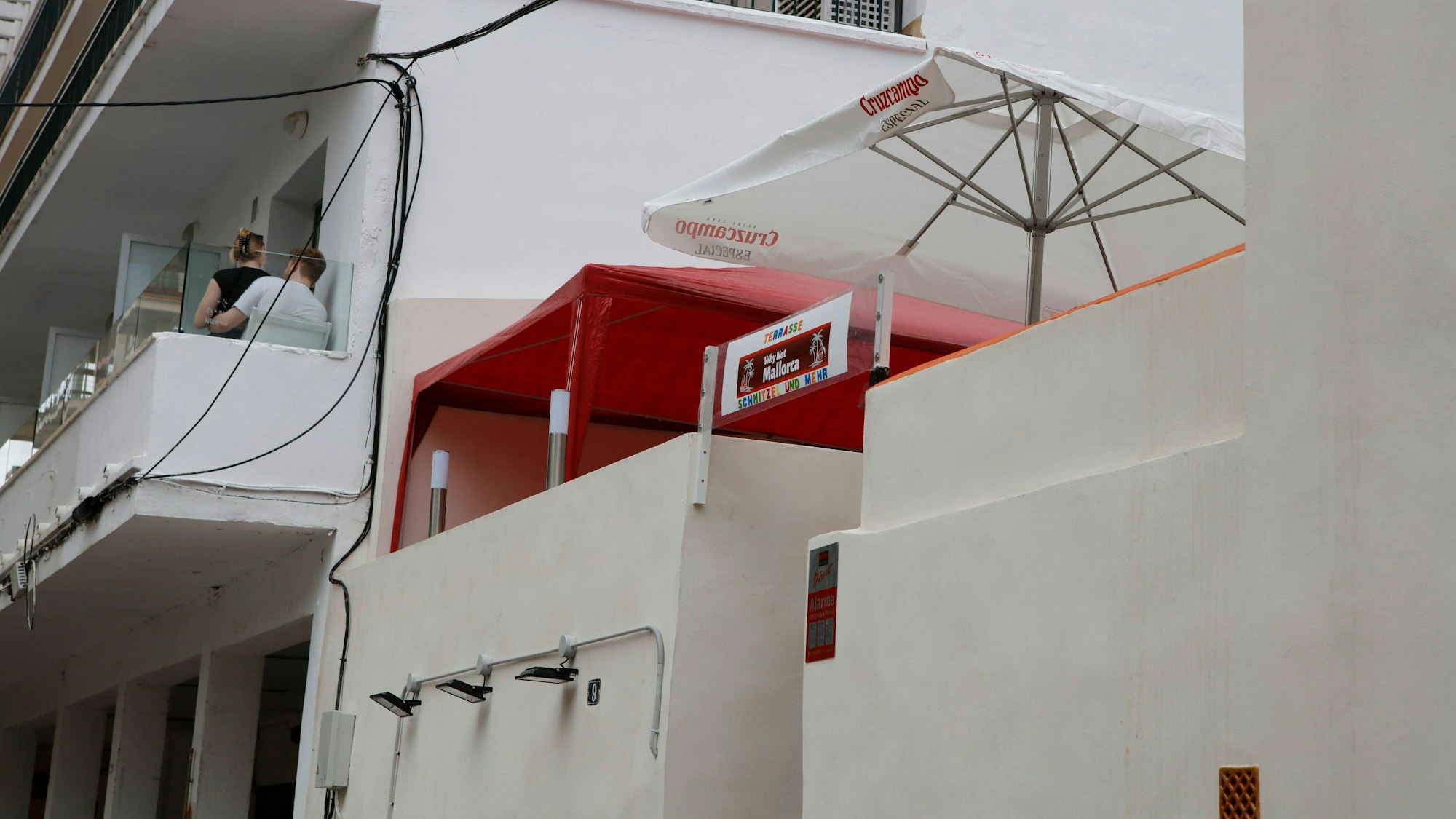 Die frisch renovierte Terrasse der Bar „Why not Mallorca“ der deutschen Besitzer Alice und Bernd Klotz. Auf der Terrasse stehen ein weiter Sonnenschirm und ein rotes Zelt.