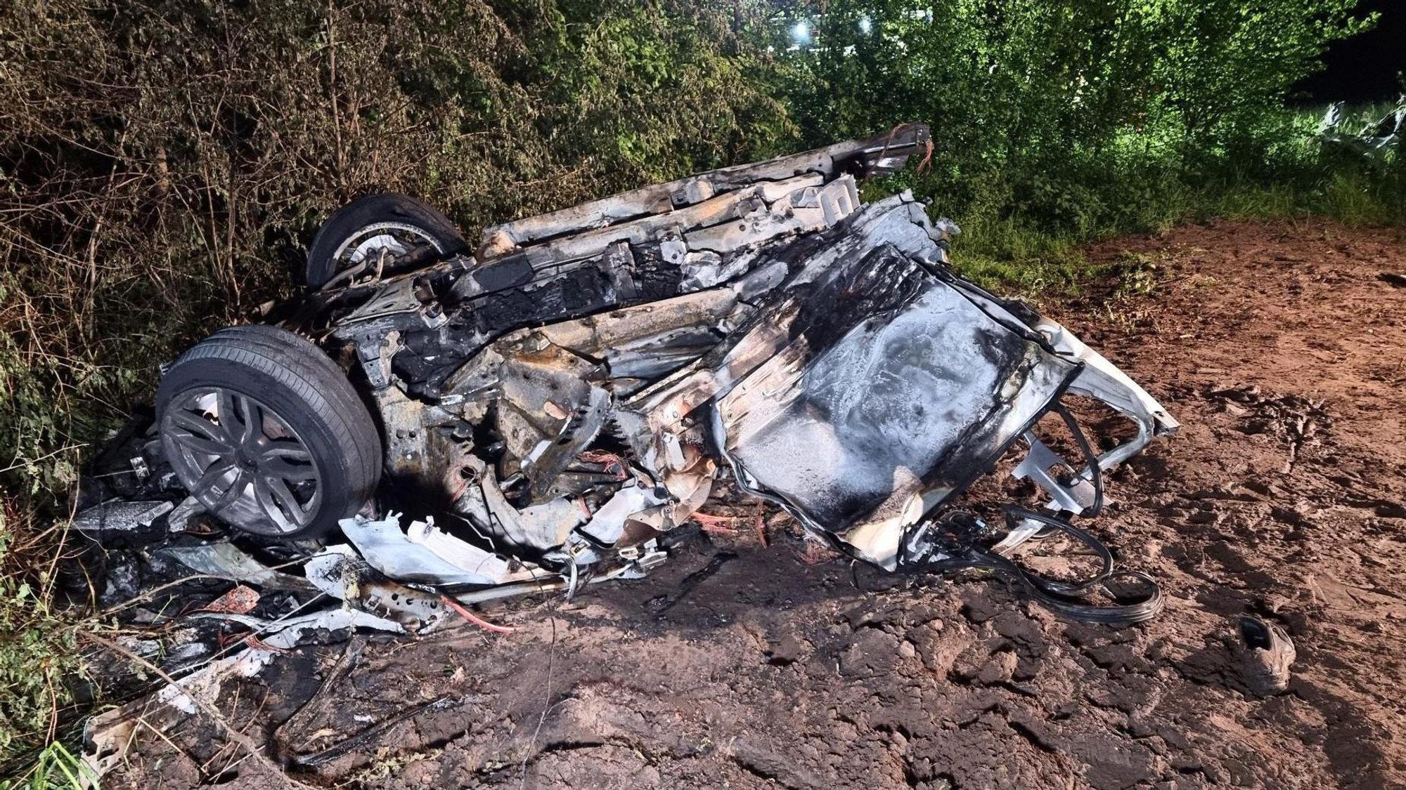 18.05.2023, Niedersachsen, Lengerich: Der hintere, abgerissene und ausgebrannte Teil des Unfallautos. Bei einem schweren Unfall sind ein Autofahrer und sein zwölfjähriger Sohn ums Leben gekommen. Ihr Wagen war mit hoher Geschwindigkeit unterwegs gewesen. In einer Rechtskurve kam das Auto von der Straße ab und krachte mit solcher Wucht gegen einen Baum, dass es in zwei Stücke gerissen wurde und in Flammen aufging. Foto: Ulf Zurlutter/Nord-West-Media/dpa +++ dpa-Bildfunk +++