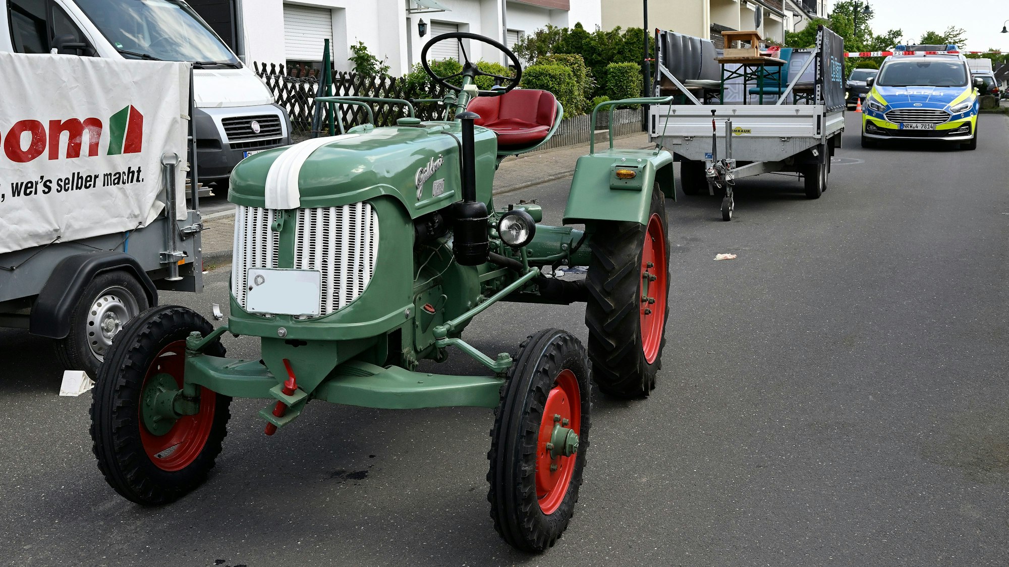 Ein Trecker-Gespann steht vor einem Polizeifahrzeug.