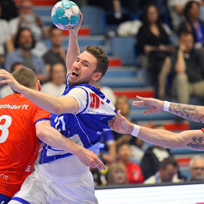 Ein Handballer wird im Angriff von zwei Gegenspielern festgehalten.