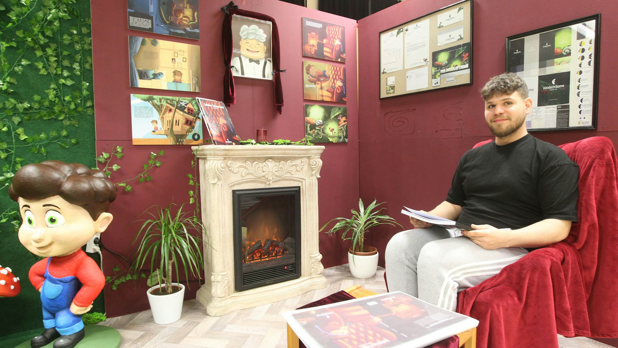 Es ist Sitki Güler zu sehen, wie er mit einem Buch in der Hand auf einem Sessel sitzt.