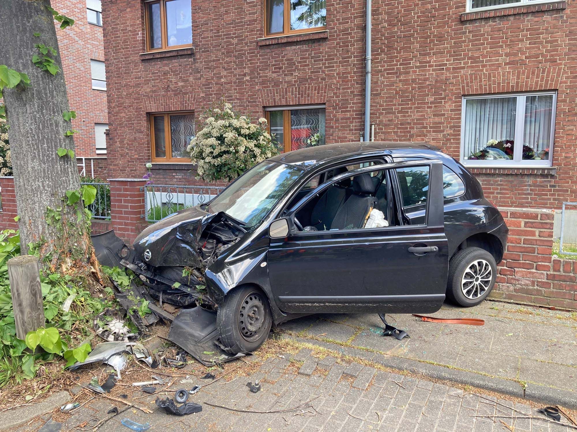 Der Pkw wurde zwischen einem Baum und einem Haus eingeklemmt.