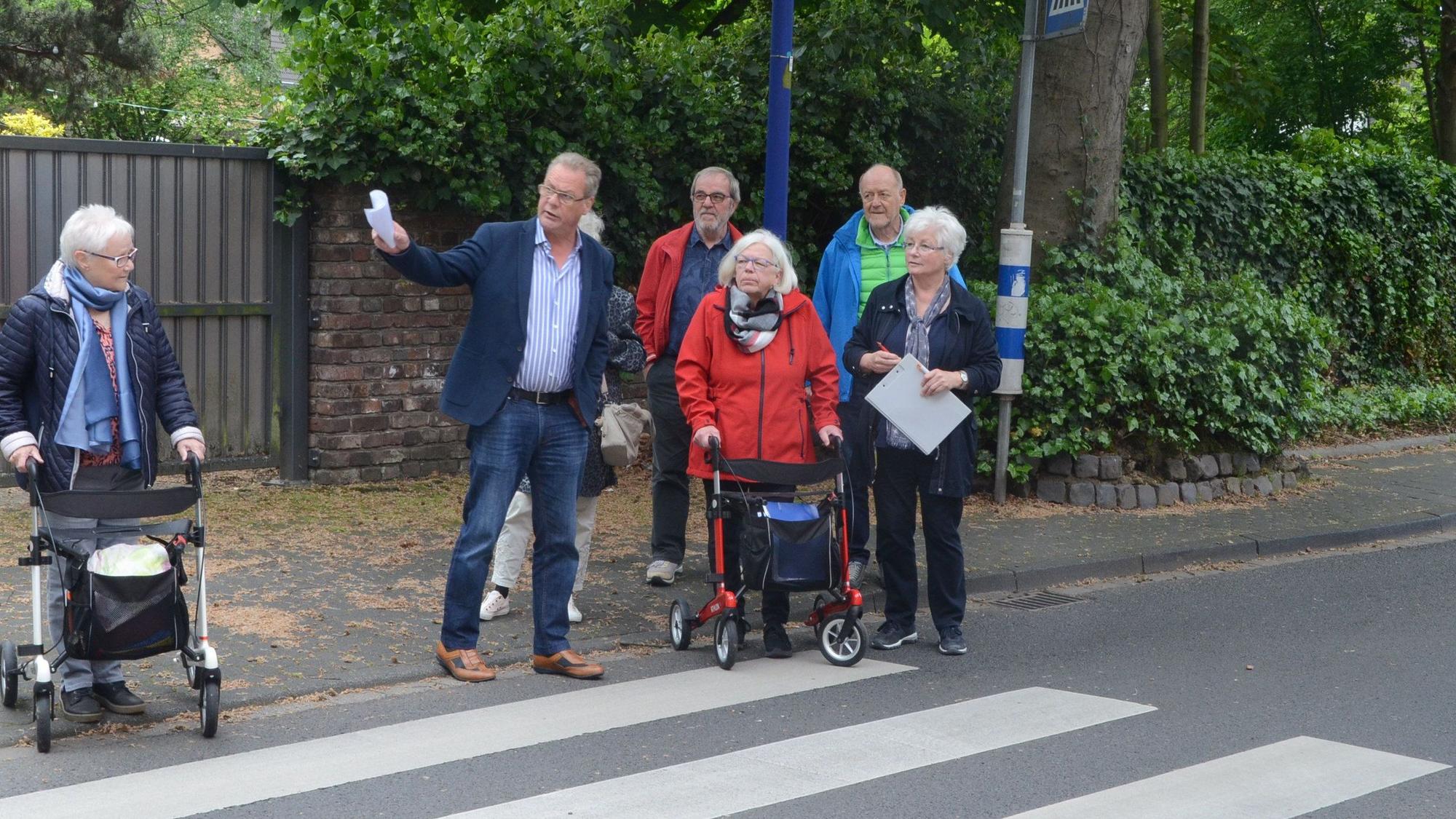Es sind mehrere Senioren vor einem Zebrastreifen zu sehen.