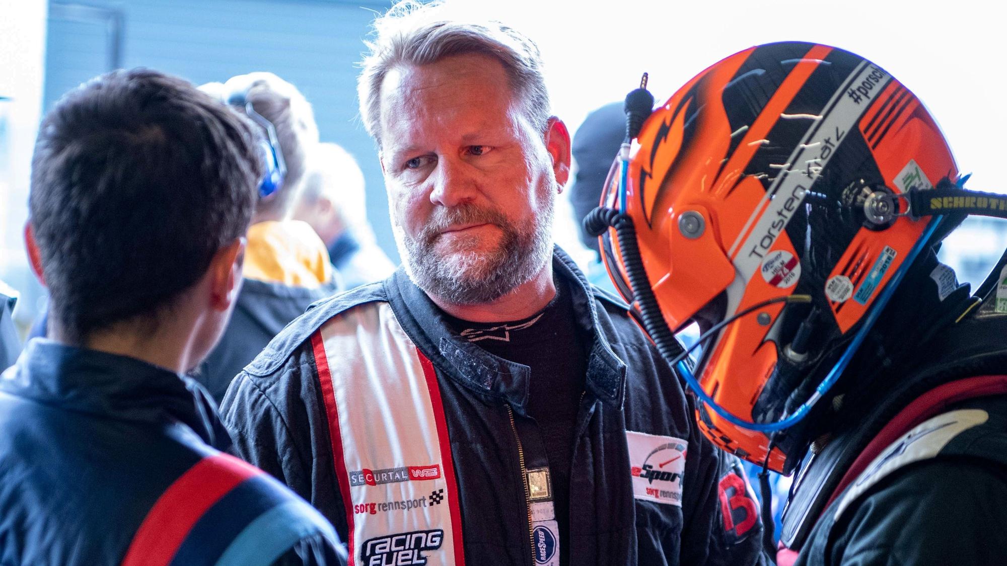 Der Weilerswister Rennfahrer Björn Simon vor dem Start beim 24h. Er ist im Gespräch mit einem Mechaniker.