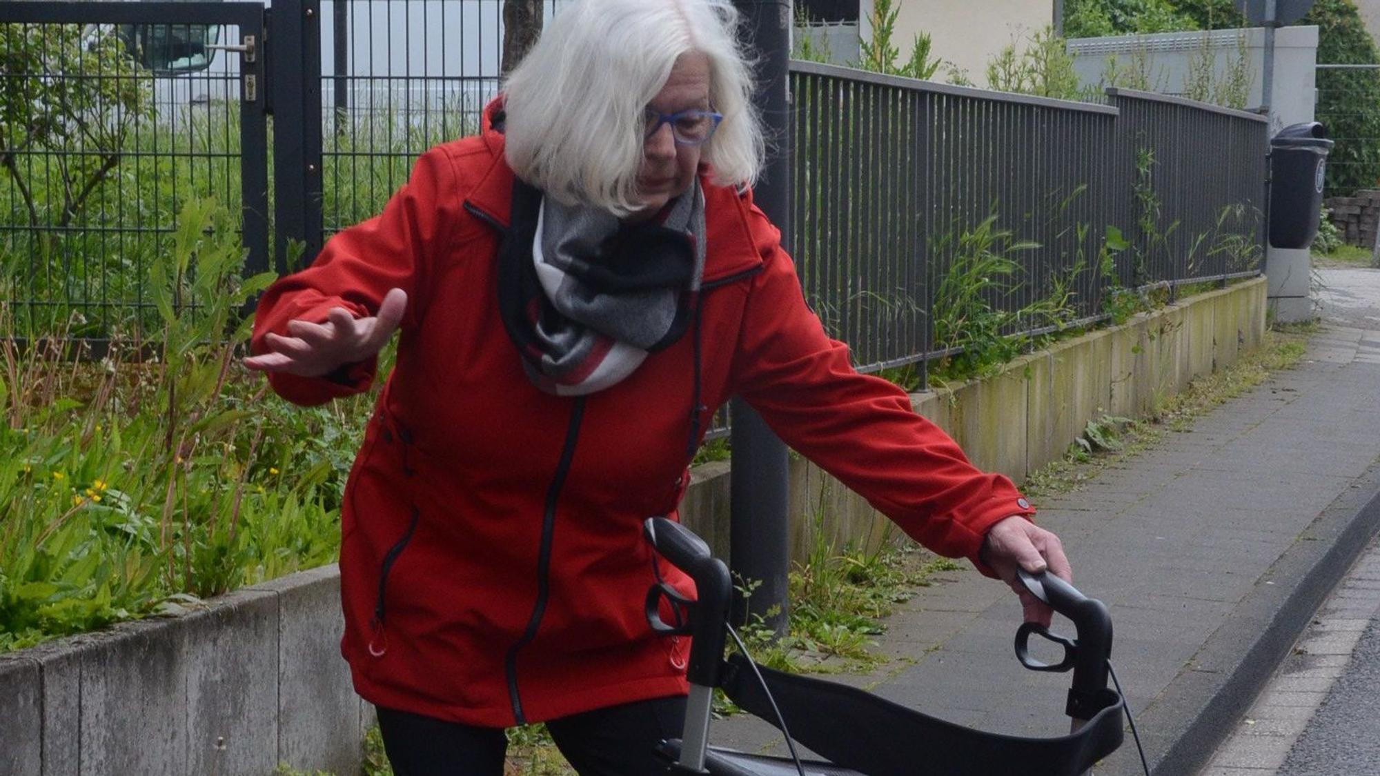 Es ist eine Seniorin zu sehen, die leicht aus dem Gleichgewicht gerät.