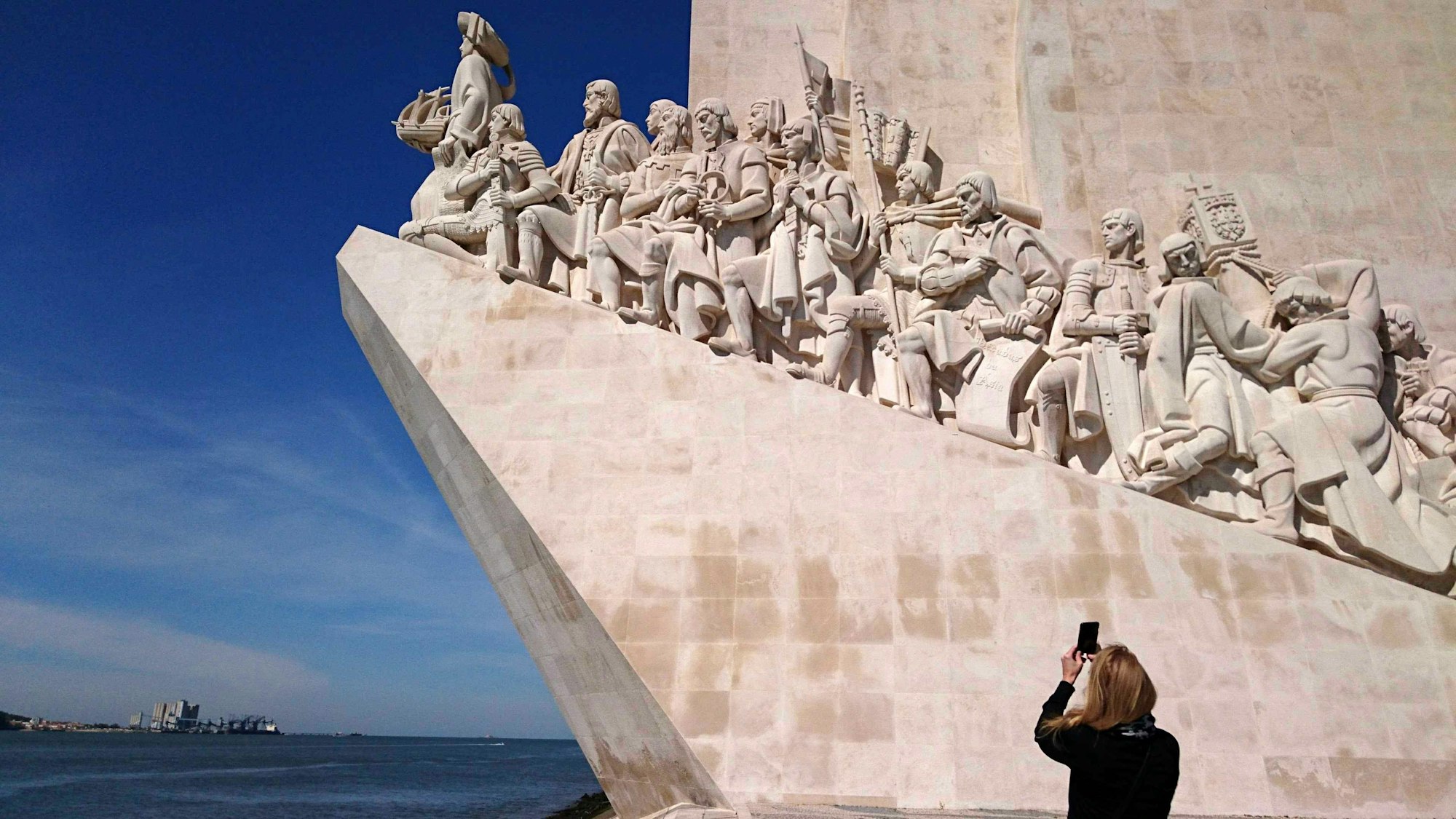 Eine Frau fotografiert das „Padrao dos Descobrimentos“ (Denkmal der Entdeckungen) im Stadtteil Belem am Ufer des Flusses Tejo in Lissabon. (Archivbild)