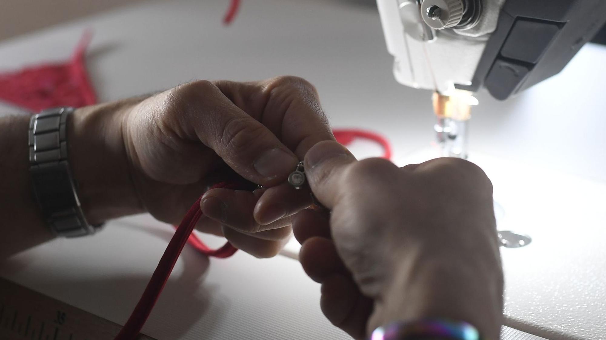 Den Schmuck befestigen die Mitarbeitenden händisch an der Unterwäsche.