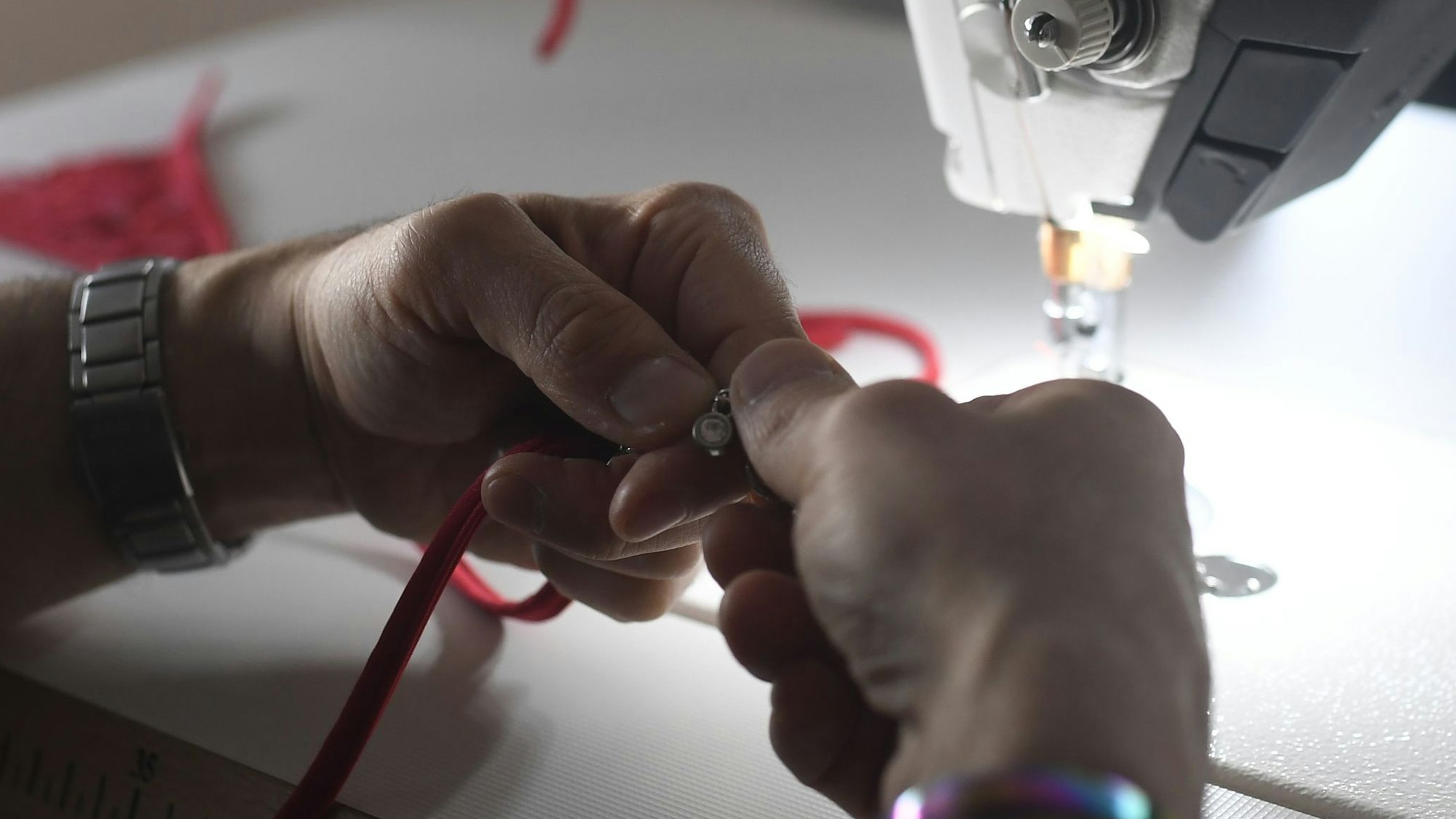 Den Schmuck befestigen die Mitarbeitenden händisch an der Unterwäsche.