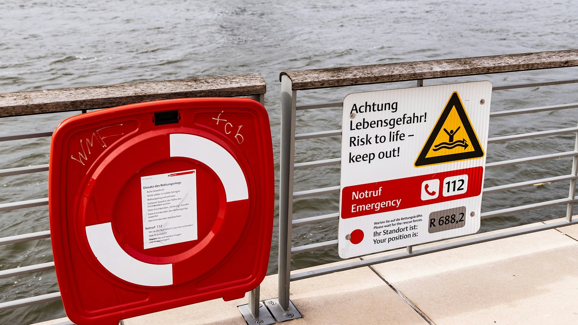 Schilder warnen am Rheinufer in Deutz davor, Schwimmen zu gehen.