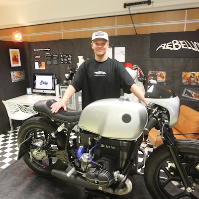 Es ist Noel Hoffmann mit seinem Motorrad zu sehen. Er schaut in die Kamera.