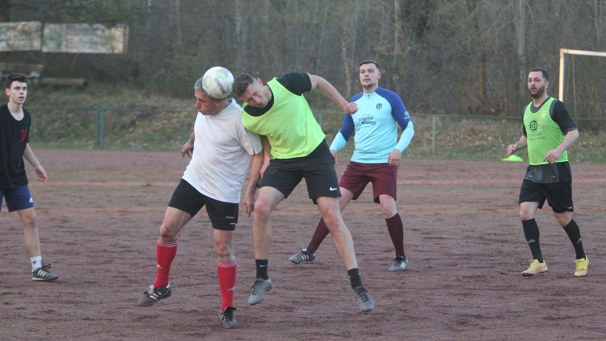 Zwei Fußballer recken sich zum Kopfball in die Höhe.