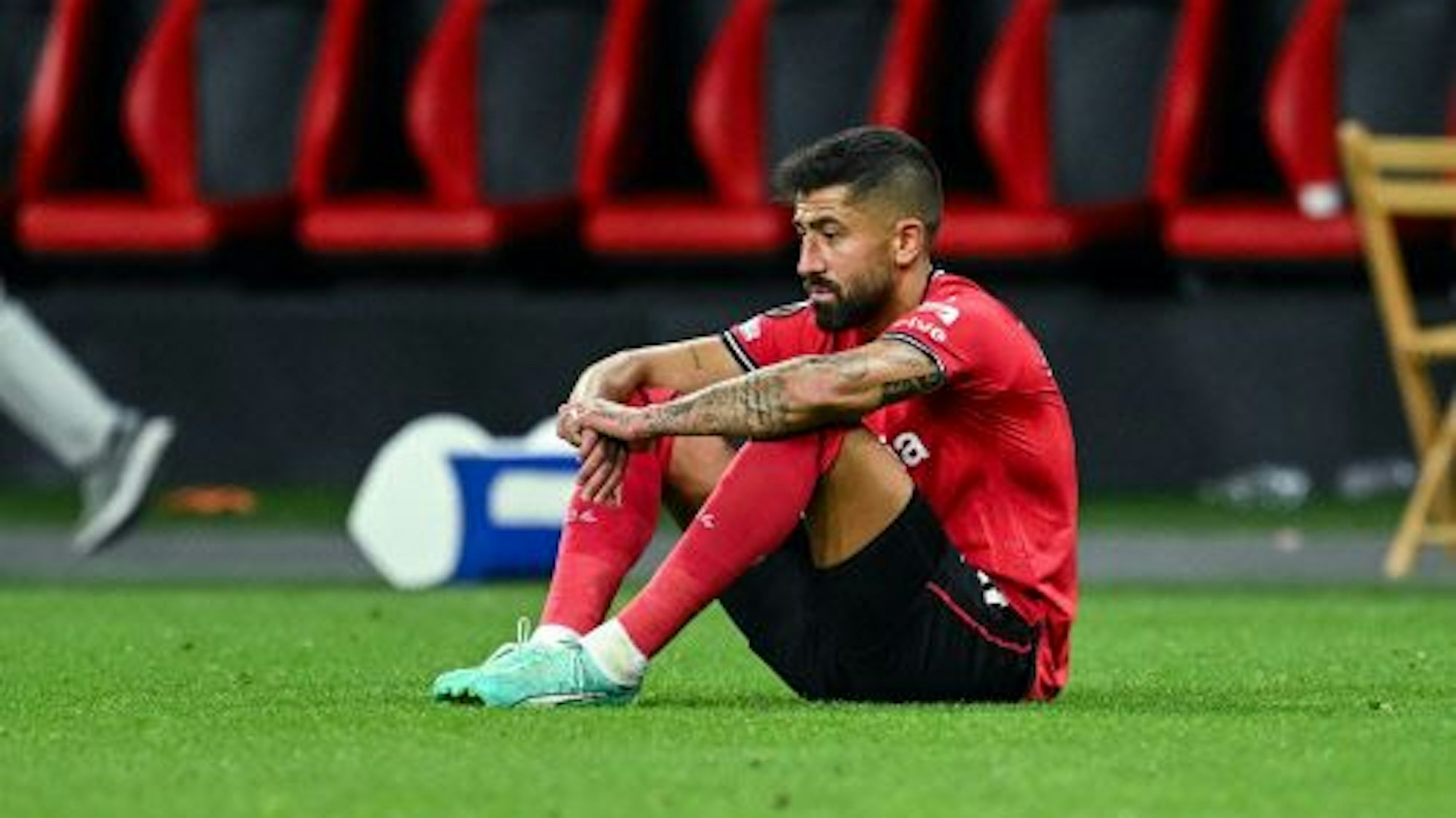 Kerem Demirbay von Bayer Leverkusen sitzt enttäuscht am Boden.