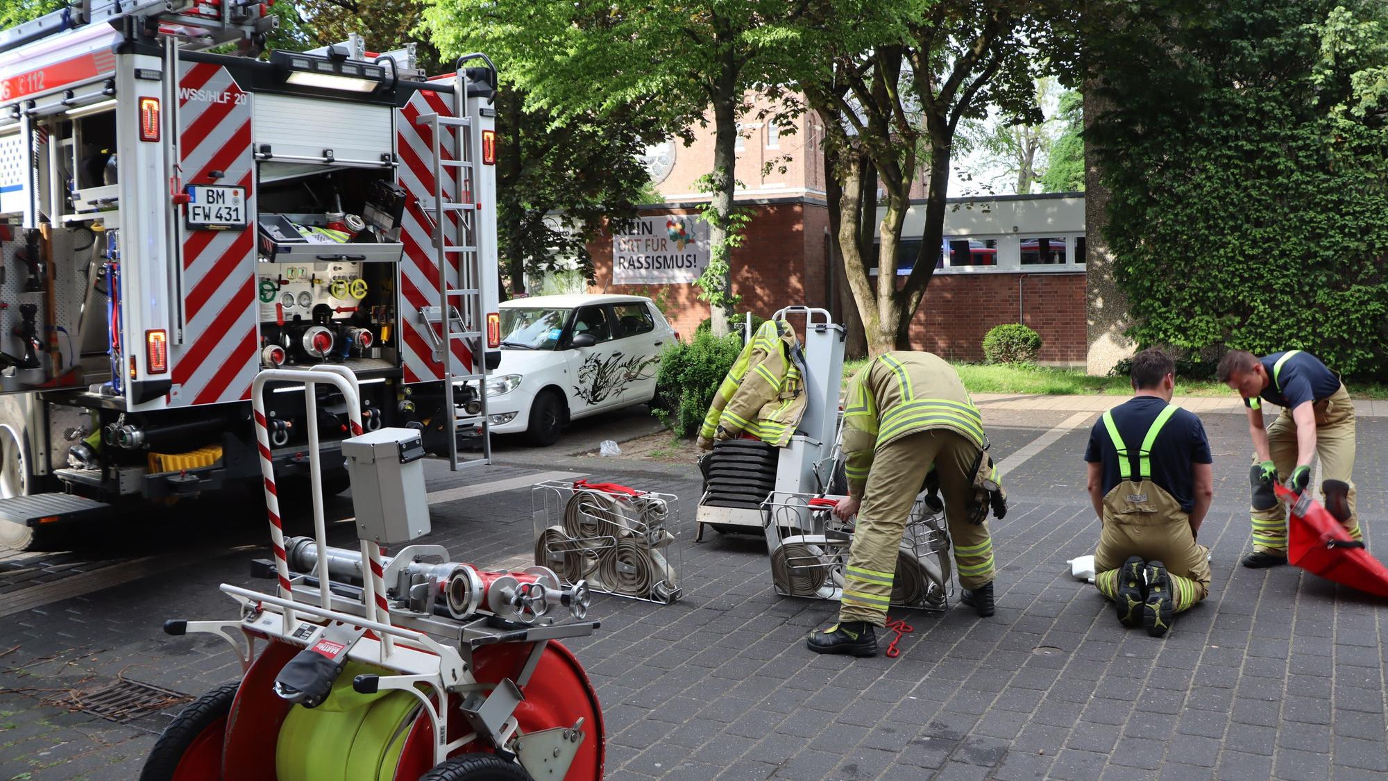 Man sieht Feuerwehrleute, die Ausrüstung verstauen.