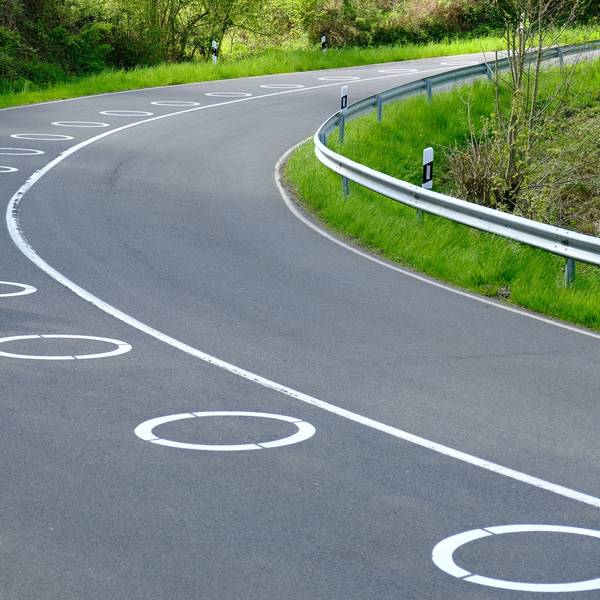 In zwei Kurven der Panoramastraße sind ellipsenförmige Markierungen auf dem Asphalt.