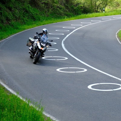 In zwei Kurven der Panoramastraße sind ellipsenförmige Markierungen auf dem Asphalt.