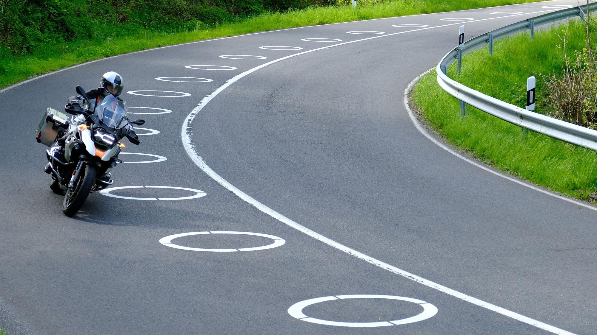 In zwei Kurven der Panoramastraße sind ellipsenförmige Markierungen auf dem Asphalt.