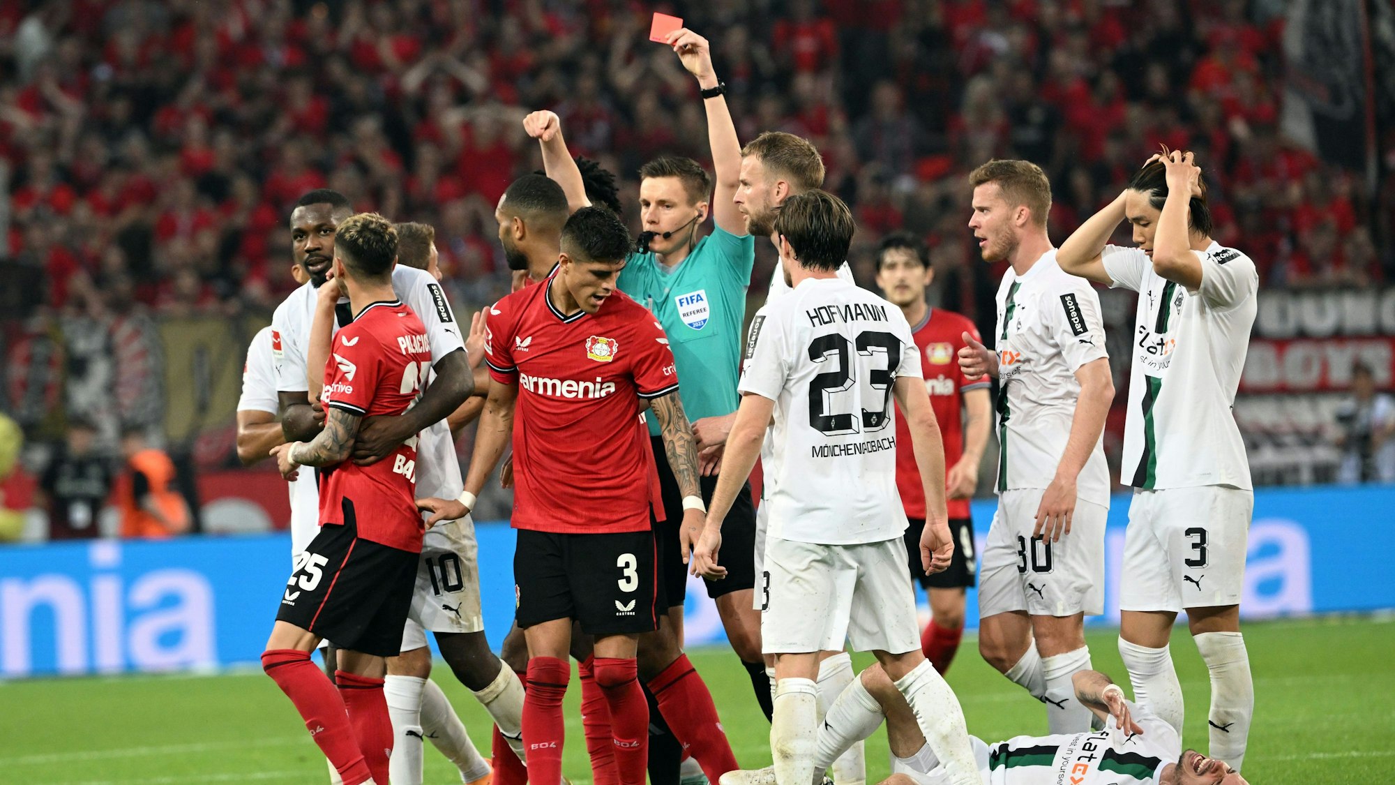 21.05.2023, Nordrhein-Westfalen, Leverkusen: Fußball: Bundesliga, Bayer Leverkusen - Borussia Mönchengladbach, 33. Spieltag, BayArena. Leverkusens Piero Hincapie (M) bekommt die rote Karte von Schiedsrichter Daniel Siebert. Foto: Federico Gambarini/dpa - WICHTIGER HINWEIS: Gemäß den Vorgaben der DFL Deutsche Fußball Liga bzw. des DFB Deutscher Fußball-Bund ist es untersagt, in dem Stadion und/oder vom Spiel angefertigte Fotoaufnahmen in Form von Sequenzbildern und/oder videoähnlichen Fotostrecken zu verwerten bzw. verwerten zu lassen. +++ dpa-Bildfunk +++