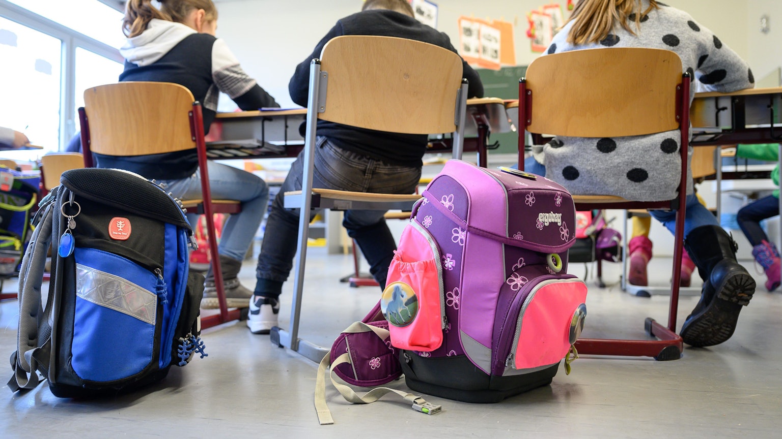 Grundschüler sitzen nebeneinander im Klassenraum.